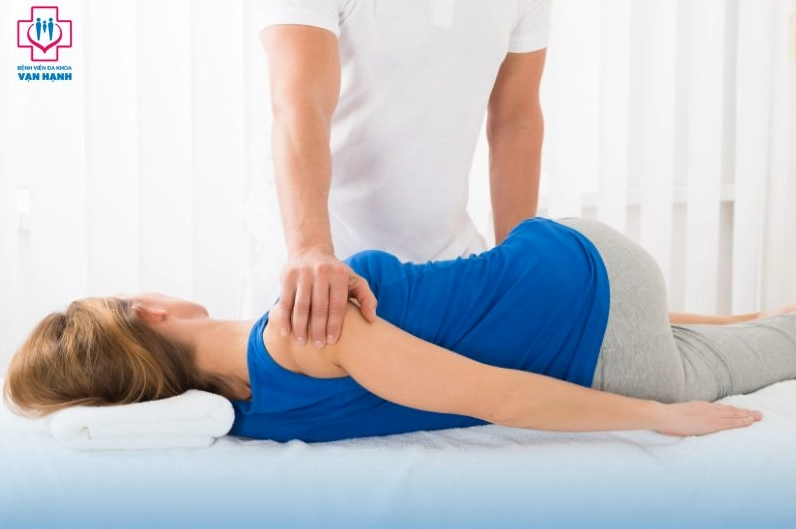 Chuyên gia vật lý trị liệu đang điều trị đau cột sống lưng cho bệnh nhân