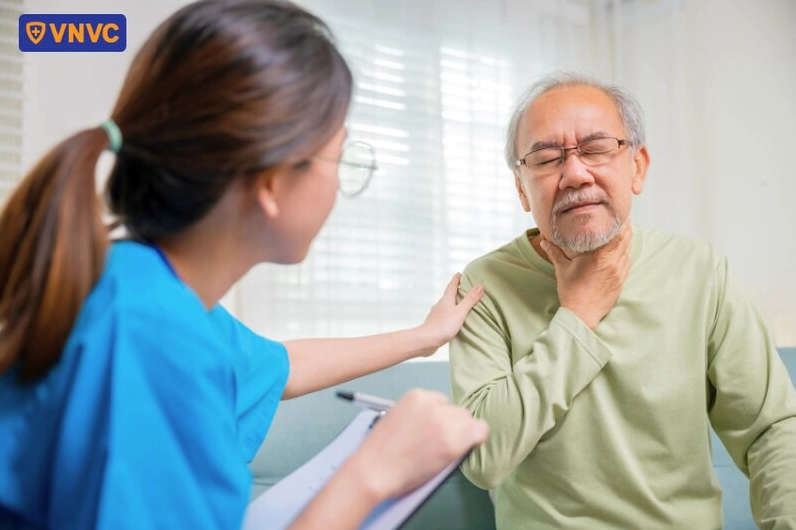 Một bác sĩ đang tiến hành thăm khám vùng hầu họng cho một bệnh nhân nam giới