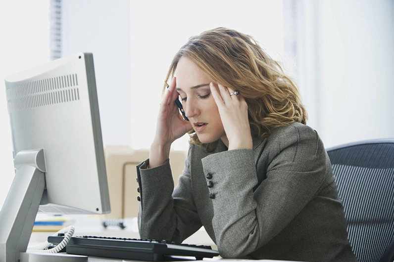 Một người trẻ đang cảm thấy căng thẳng và ôm bụng đau do áp lực công việc