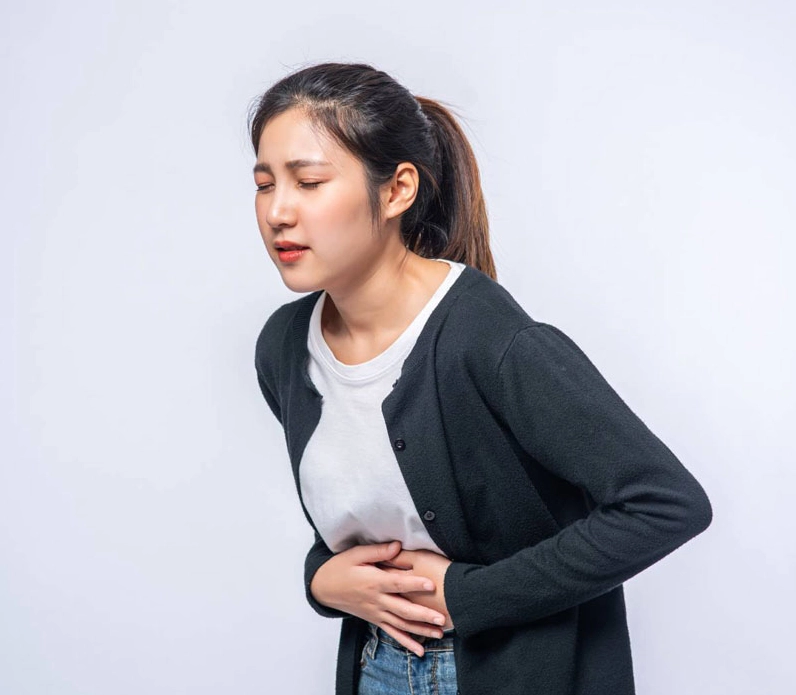 Một người đàn ông đang ôm bụng thể hiện cảm giác đau âm ỉ kéo dài.