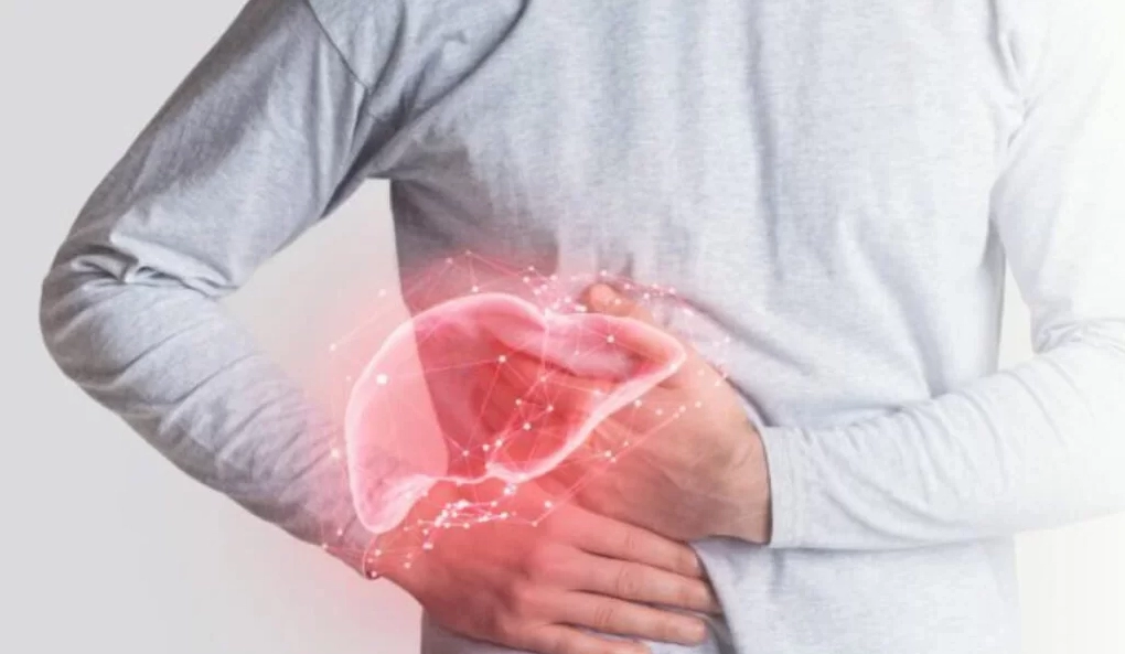 Một người đàn ông đang ôm bụng thể hiện dấu hiệu đau tức vùng hạ sườn phải của bệnh ung thư gan